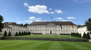 Schloss Bellevue mit deutschen und europäischen Flaggen im Berliner Park