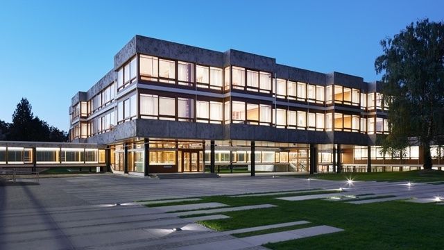 Beleuchtetes modernes Gerichtsgebäude bei Abenddämmerung